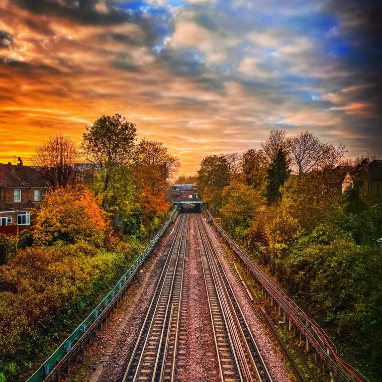 West London train tracks set in front of a stunning red sunrise