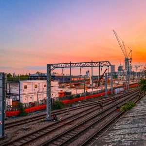 Train lines running along the side of an industrial estate at sunset in West London