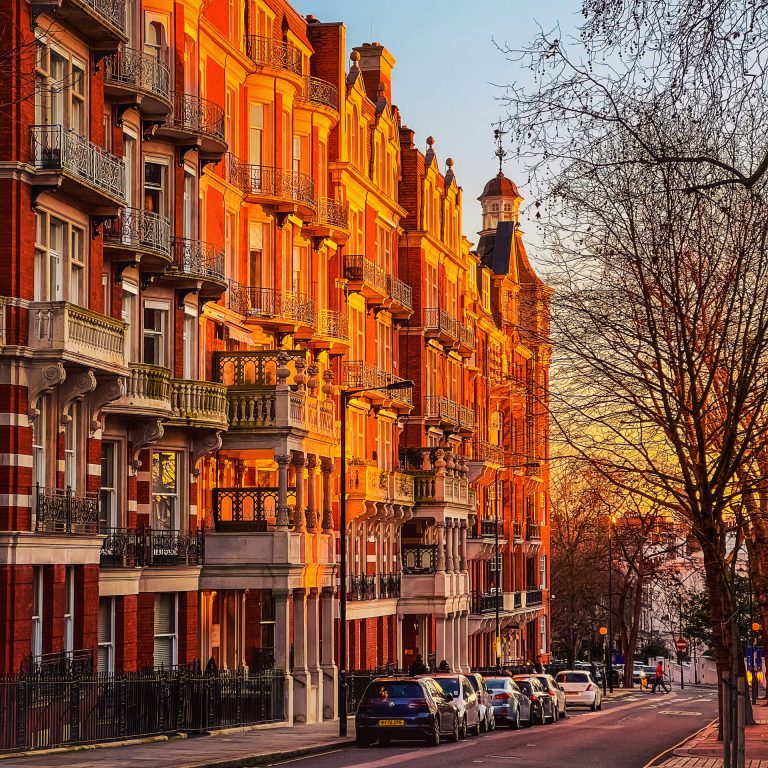 A classic view of a West London street with orange brick houses and a white trim