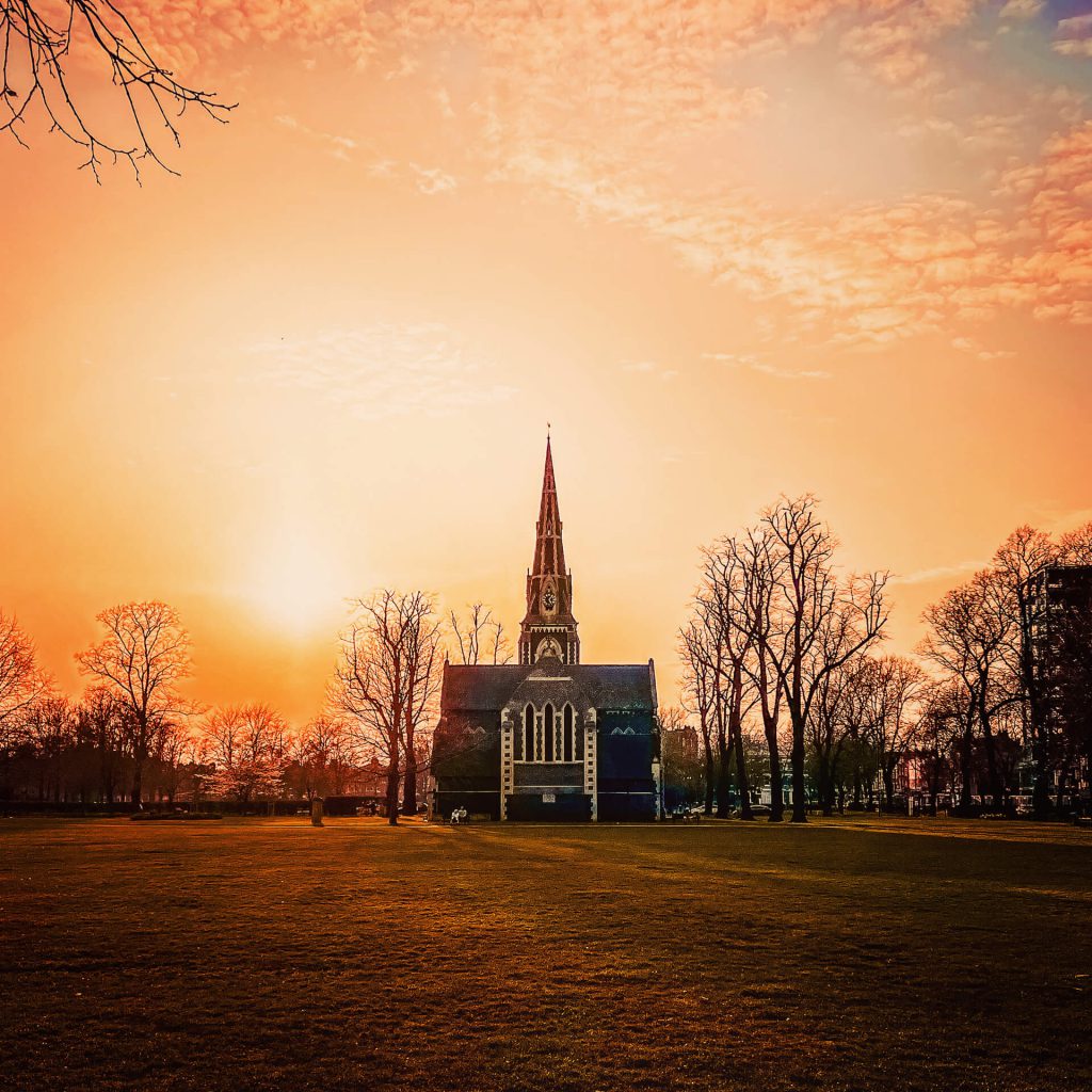 A beautiful orange sky set behind a Gothic church