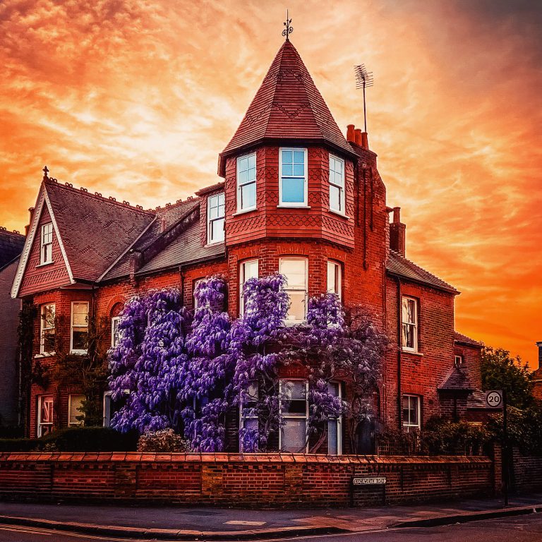 A stunning red brick house with a turret style roof