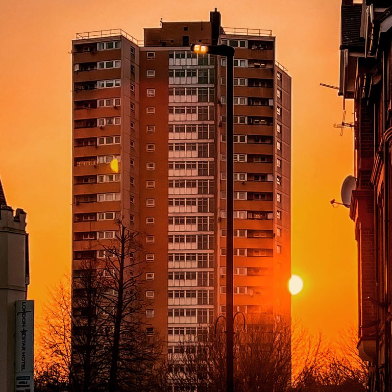 A block of flats in on Horn Lane in Acton set against a majestic sunset sky