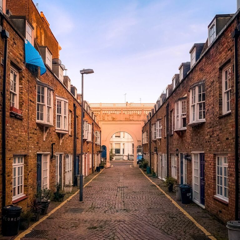 A cobbled mews in West London with an archway at the far end