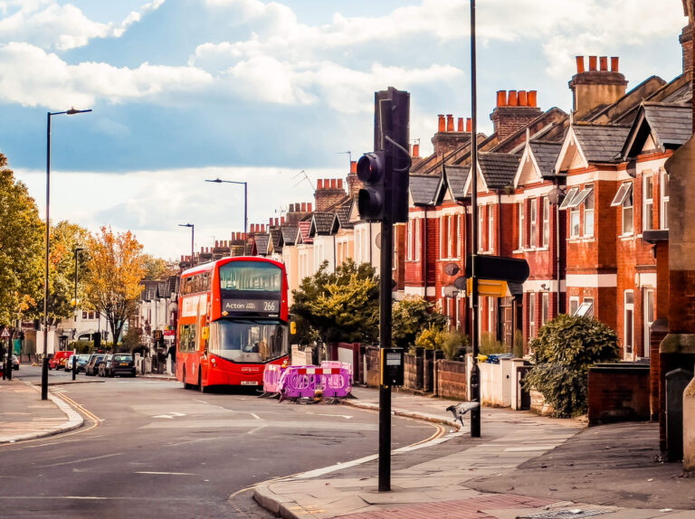 The 266 bus to Acton travelling along a street of red-brick houses in W3